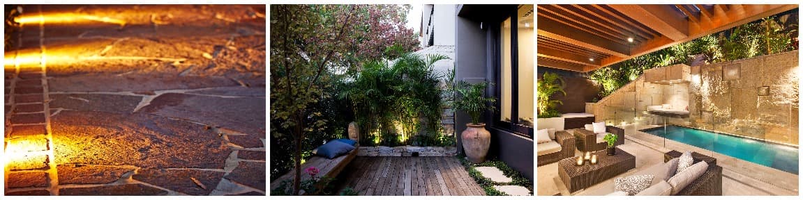 Outdoor lighting after dark, uplit stone paving, a lit courtyard and a glowing poolside lounge