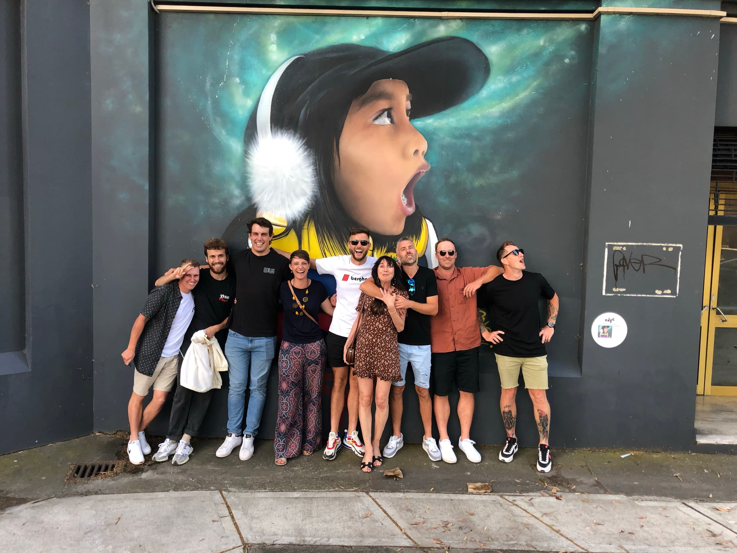 The Growing Rooms team standing together in front of a Sydney street-art mural