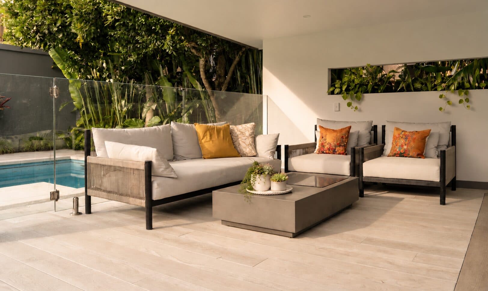 Covered cabana seating beside the pool with a leafy garden outlook